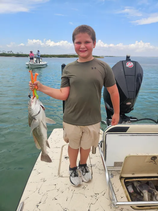 Wyatt holding a fish on a boat